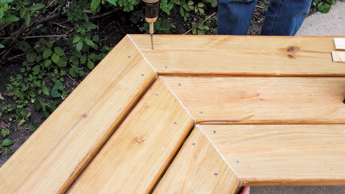 Once you are happy with the arrangement, drill pilot holes and drive screws to attach the boards to the horizontal supports.