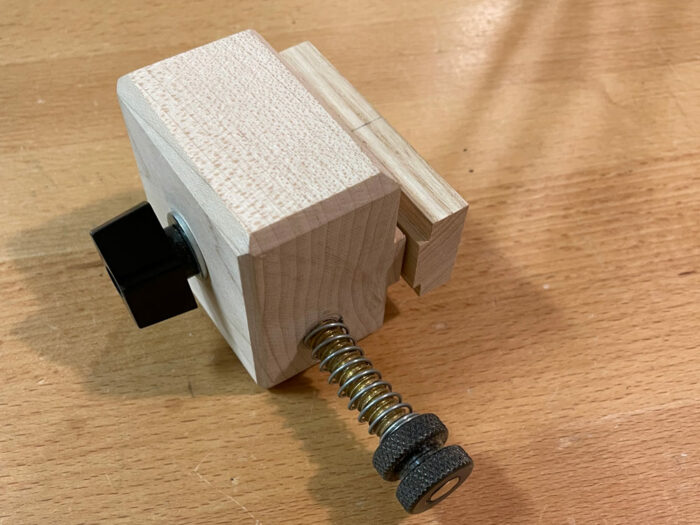 a block of wood with screws through it that attach to a tablesaw fence