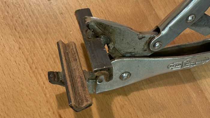 a pair of vise-grip style pliers with metal and leather attached to the jaws