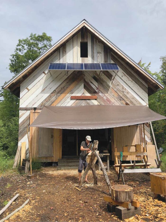 man under tarp on working on wooden project