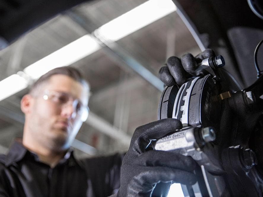 Service technician working on brake pads at Feldman Chevrolet of Lansing