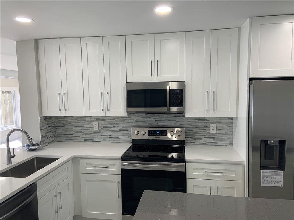 Brand new shaker door cabinets with quartz counter tops and custom glass backsplash