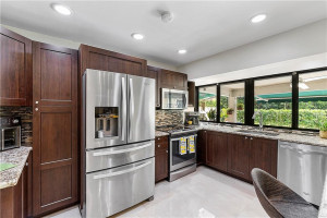 Granite counters boast glass tile backsplash.
