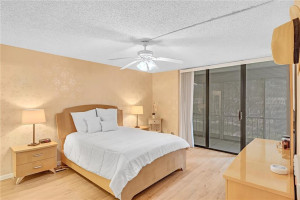bedroom has balcony with view of garden to pool
