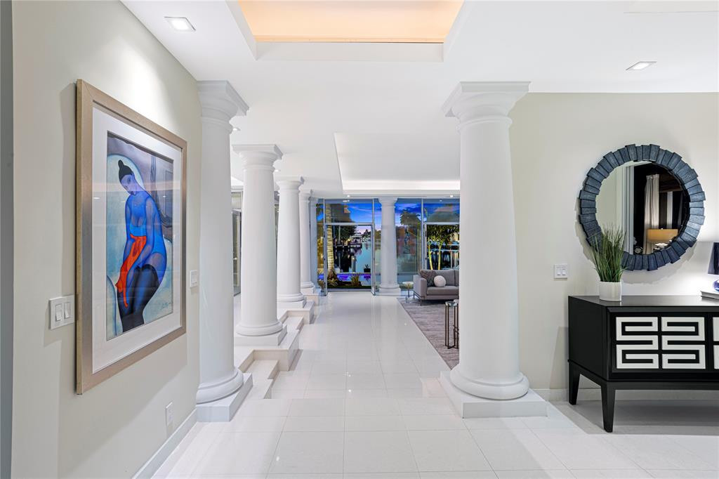 Entry foyer as you go inside the front doors. Walls of glass line the back of the house showing the vast waterway.