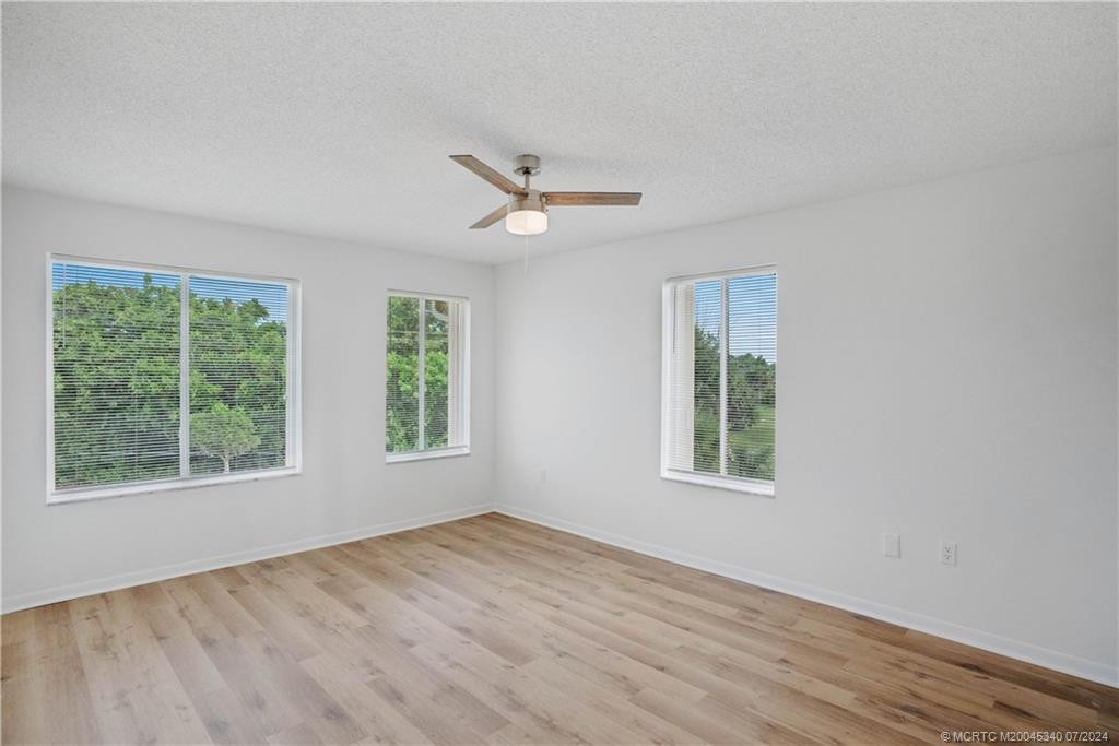 Main Bedroom with New flooring and new window blinds and ceiling fan.