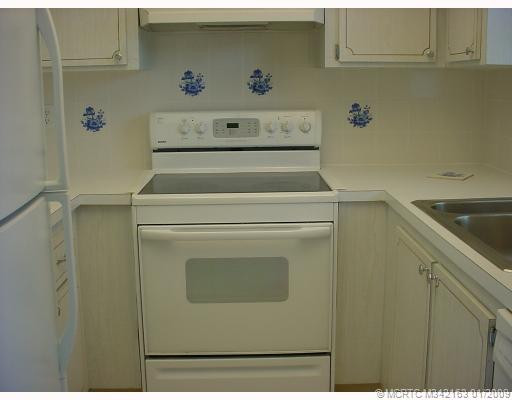 Kitchen. White tiled kitchen with blue accents.