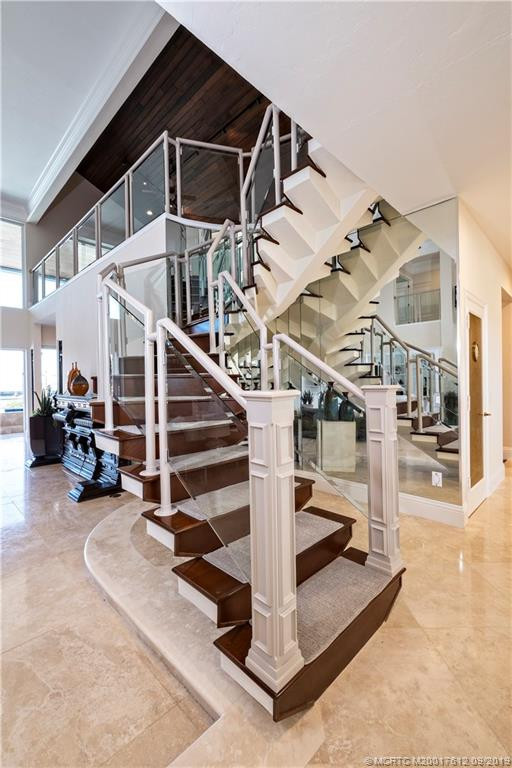 Architectural staircase to upper level loft/game room/office and VIP guest ensuite with private balconies and tranquil water views.