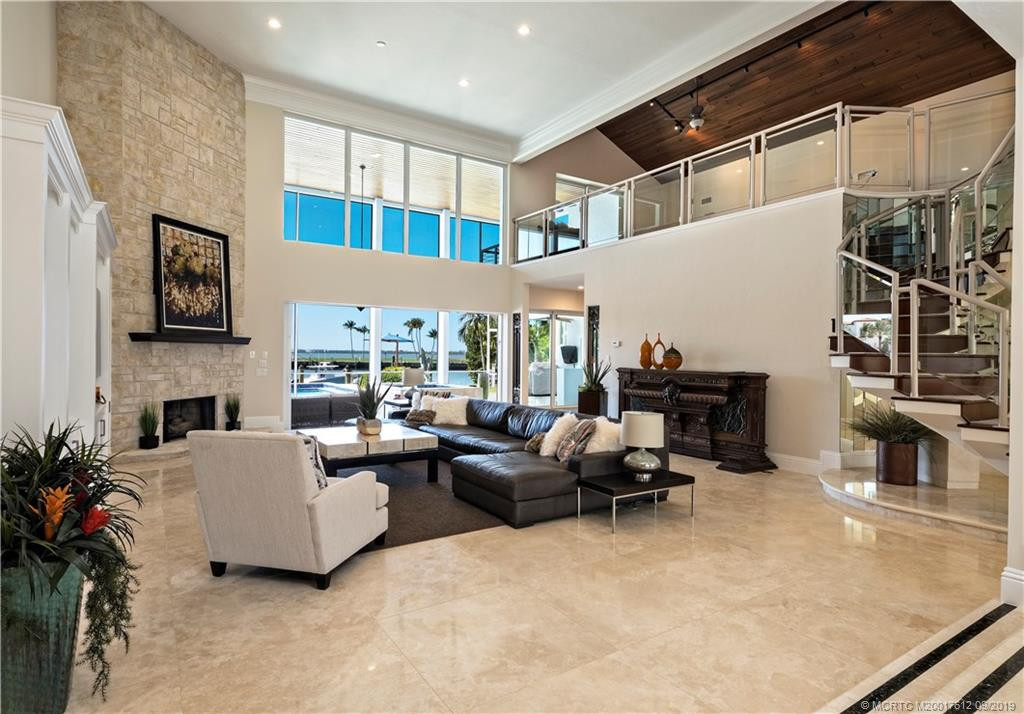 Greatroom with travertine floors and pocketing sliders to lanai, pool, spa and private dock at water's edge.