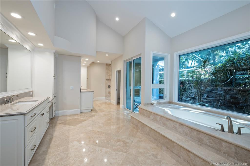 Master bath surrounded by privacy garden lined with stacked stone walls and landscape lighting.