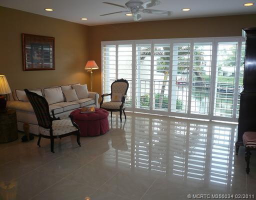 Living Room. Extended Living Room has beautiful water view of Lagoon through Plantation Shutters at sliding impact glass doors w/balcony. New porcelain tile floor, freshly painted walls, new recessed high-hat lighting & ceiling fan