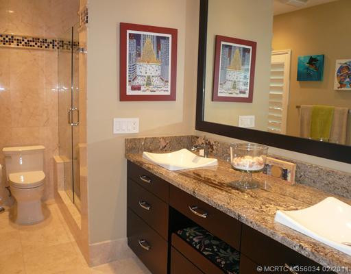 Master Bath/Spa. Exquisite & gracious master spa has been reconfigured & upgraded in granite & marble, large framed mirror, smooth finish ebony vanity w/matching seat, dual basins & self-closing drawers, new Toto toilet w/soft close lid, frameless glass shower enclosure