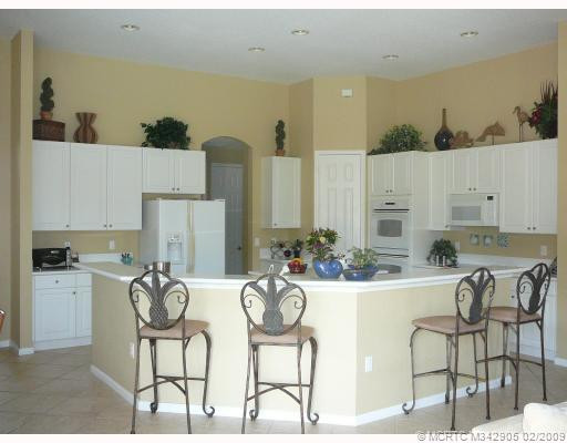 Kitchen. Dual convection ovens, Kitchen island with storage, prep sink and disposal, corian countertops, large breakfast bar seats6 or more, tile on diagonal. Kitchen exits to computer work station, to laundry room exiting to 3 car garage.