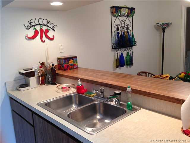 Kitchen. kitchen has view of dining area- open bright with cabinets removed overhead and lights put in that space