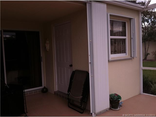 Exterior Front. storage area with separate door and window..hurricane shutters closing over roofed part of porch-