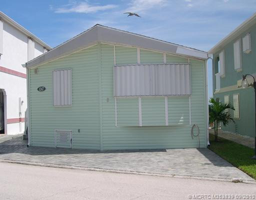Exterior Front. Pavered lot, vinyl siding, accordian hurricane shutters