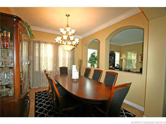 Exterior Front. Formal dining room with open arches overlook the living room.