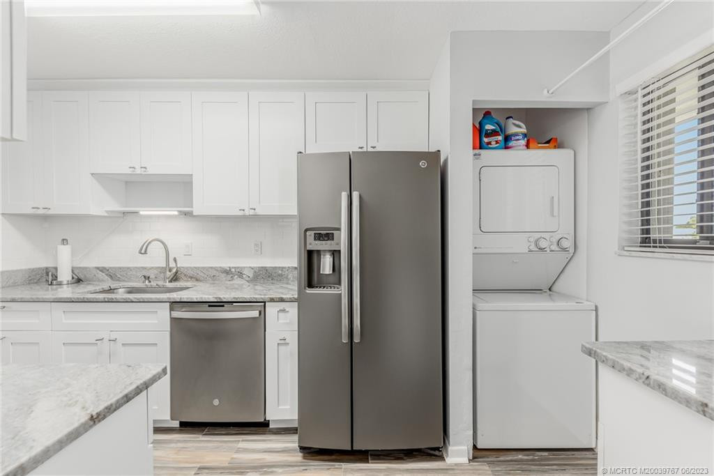 Large new kitchen has stackable washer/dryer and counter for sorting clothes