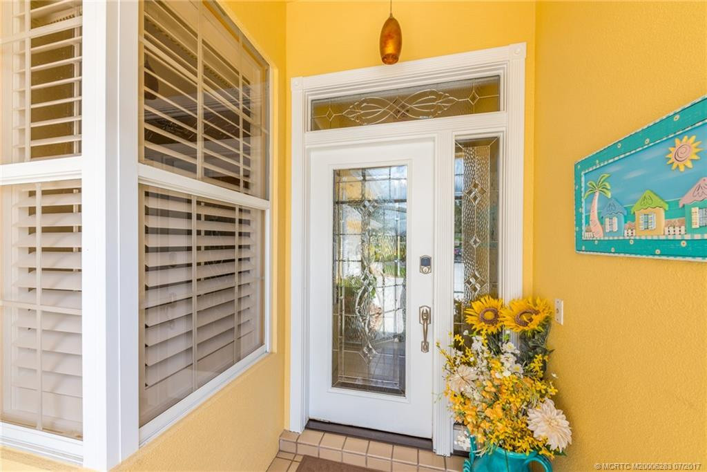 Sunny & welcoming covered entry with upgraded hurricane rated front glass front door.