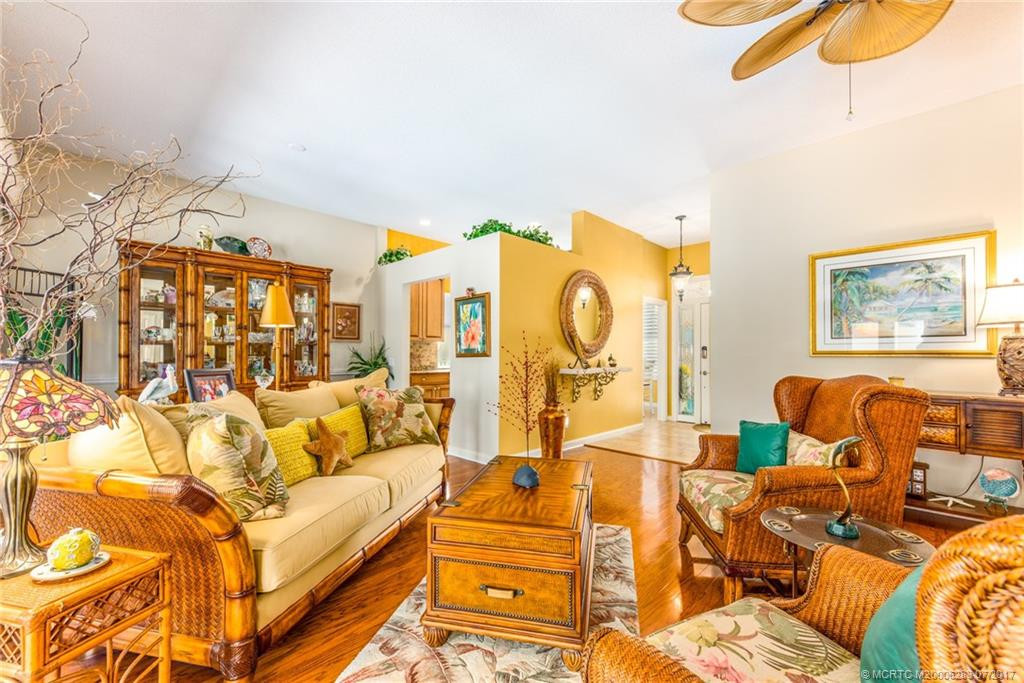 Spacious & well appointed Great Room. The perfect place to entertain family & friends!! Custom paint, designer paddle fans & gleaming hardwood flooring.