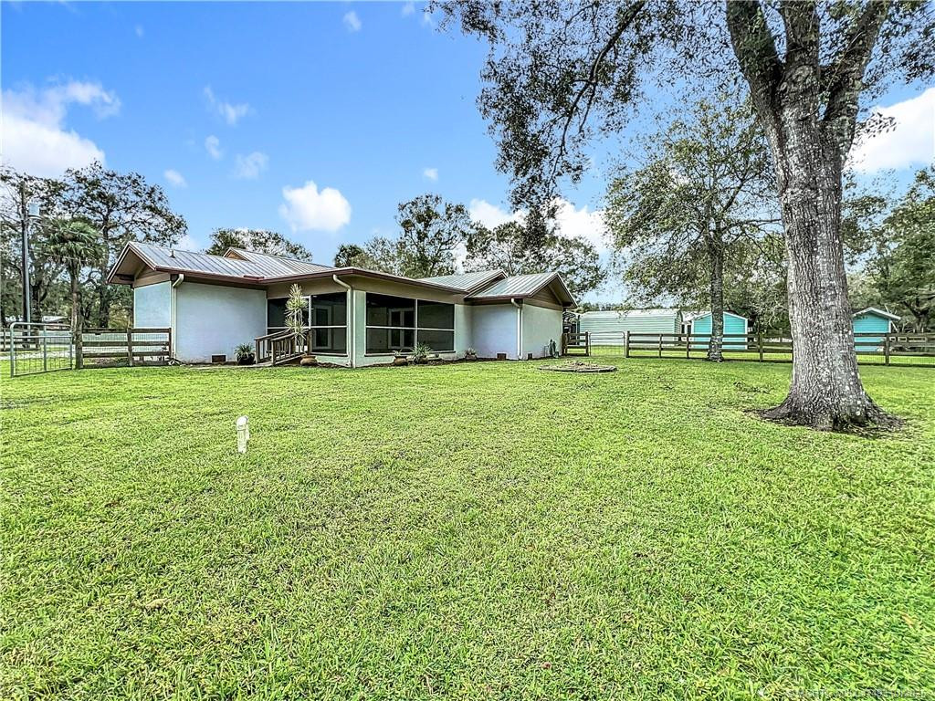 You have a ramp to go into the back porch patio area all screened in and fan with lights. The home is block with stucco. Metal room and fenced. The home goes beyond the fench in front of you. Gutters and down spouts.