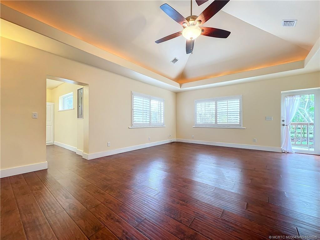 Impact glass front door, large windows with plantation shutters, high ceilings with tray ceilings with lights around it. Laminate floors. The entry door goes into the laundry room and storage area inside ac with waher and dryer, lots of storage. Fan with a light, flows into the kitchen and out the French doors to a large back screened porch.