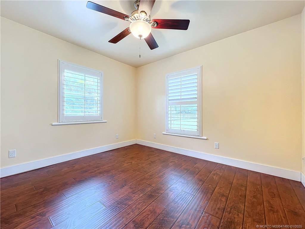 2 windows and plantation shutters. Fan with a light, closet across the wall.
