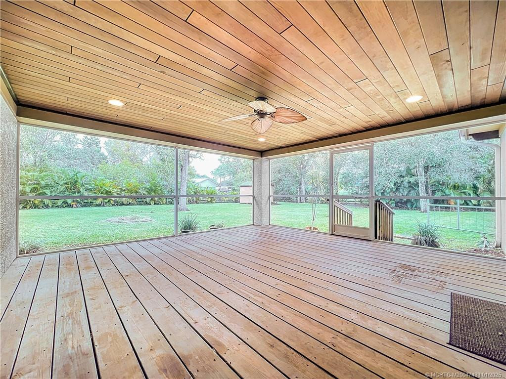 Large screened porch, look at this beautiful , wood floors and wood ceiling with a set of French impact doors to primary bedroom and kitchen great room area.
