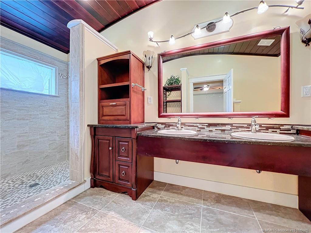 Large bathroom with double sinks large shower with double heads one on each side all tiled. Look at the beautiful wood ceiling and it is arched.