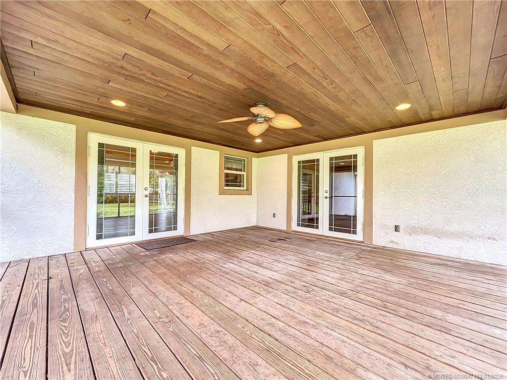 Back porch off the kitchen and primary bedroom with impact windows, window in kitchen over the sink for that great view., fan and lights.
