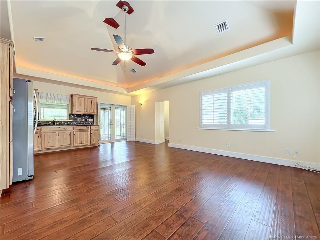 This is the kitchen and great room area. Look at the high ceilings tray ceiling with lights all round it. Laninate flooring with all impact windows, plantation shutters. Fresh paint. The Kitchen has stainless side by side refig. and gas stove. French door all impact. Window over the sink. stainless sink.