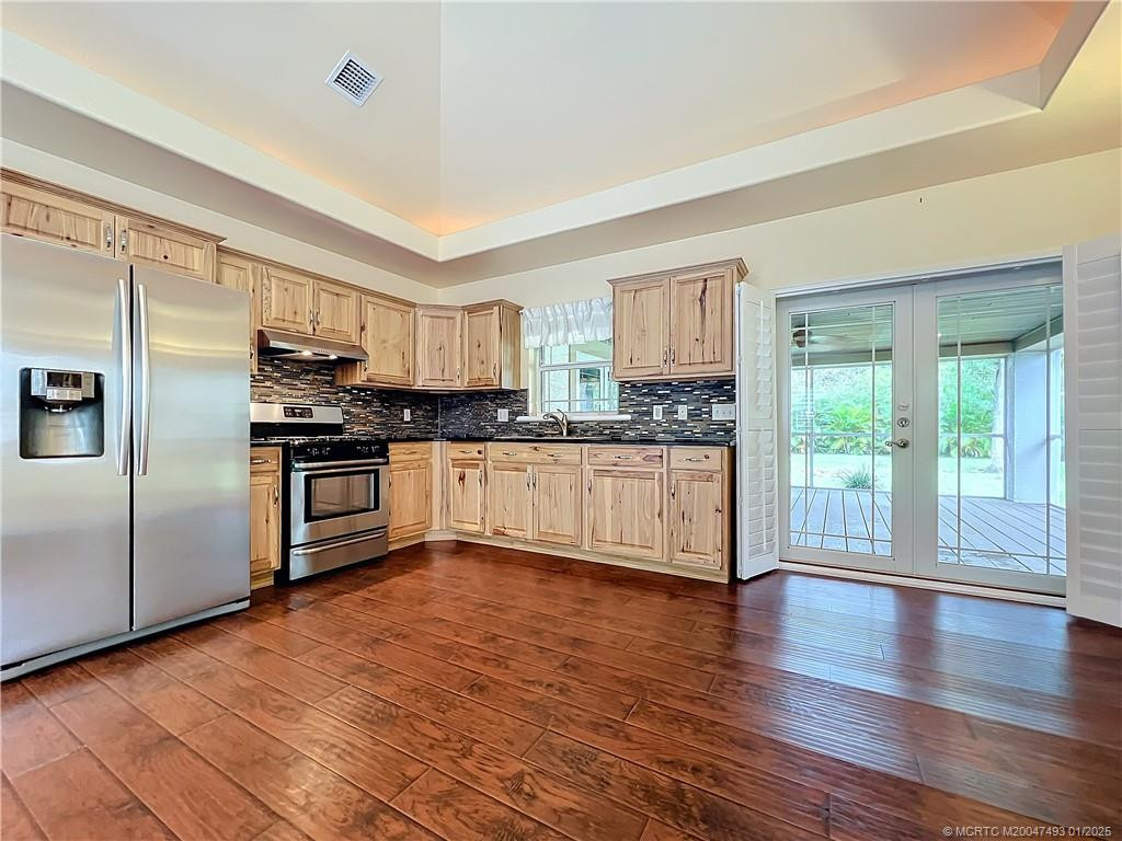 Impact French doors to large, screened porch. Laminate floors, gas stove and side by side refig., Window over the sink Look at the beauty of that backsplash. High Tray ceilings with lights in them.