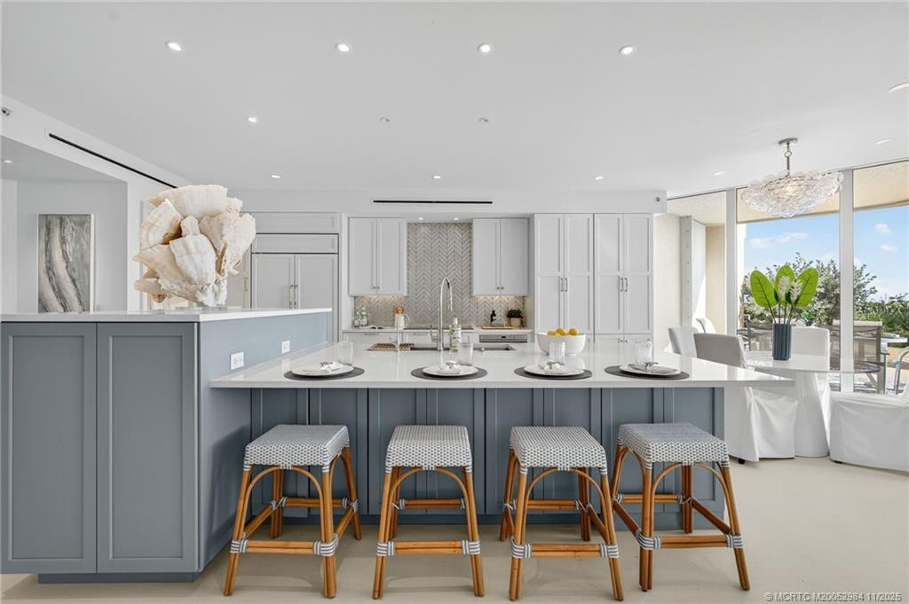 Kitchen island seats four. Sub-Zero beverage refrigerator conveniently tucked in at the end of the island