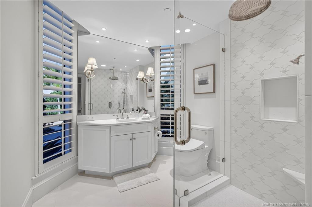 Custom tile, plantation shutters, and frameless shower door