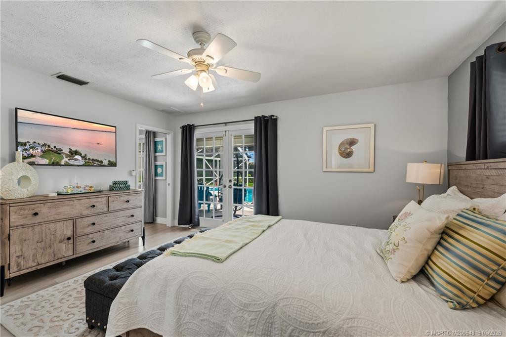 Primary bedroom with French door access to the pool and covered and screened patio
