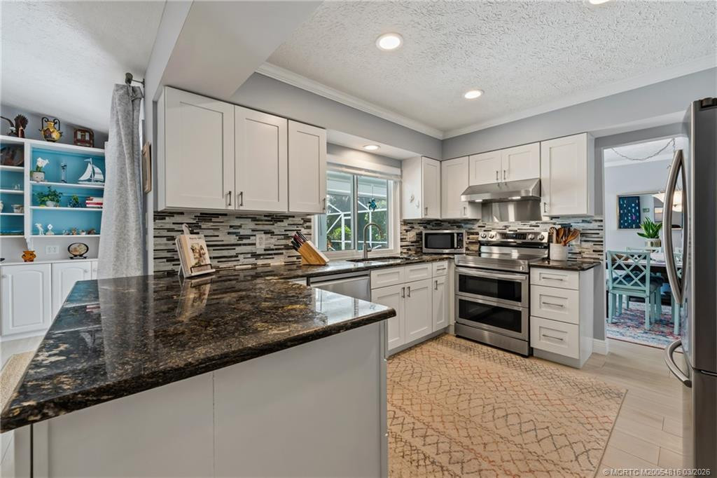 Updated kitchen with updated stainless steel appliances and pass through window to the patio