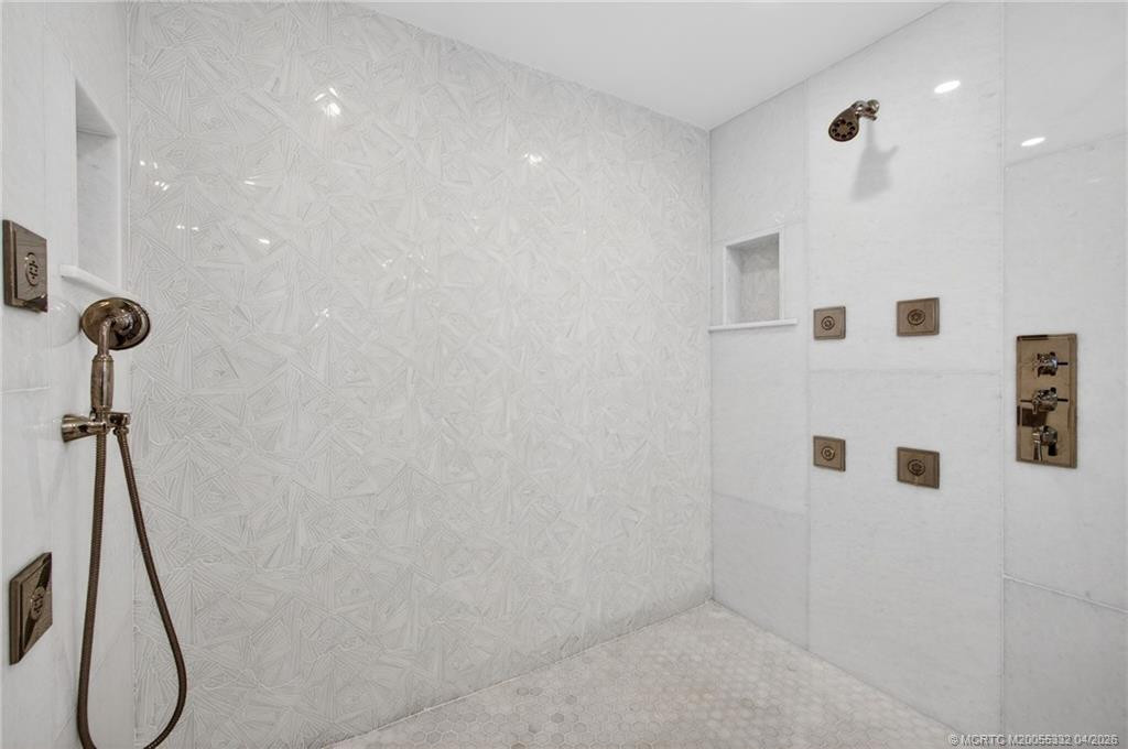 This shower has stunning tilework, multiple shower heads and body sprays