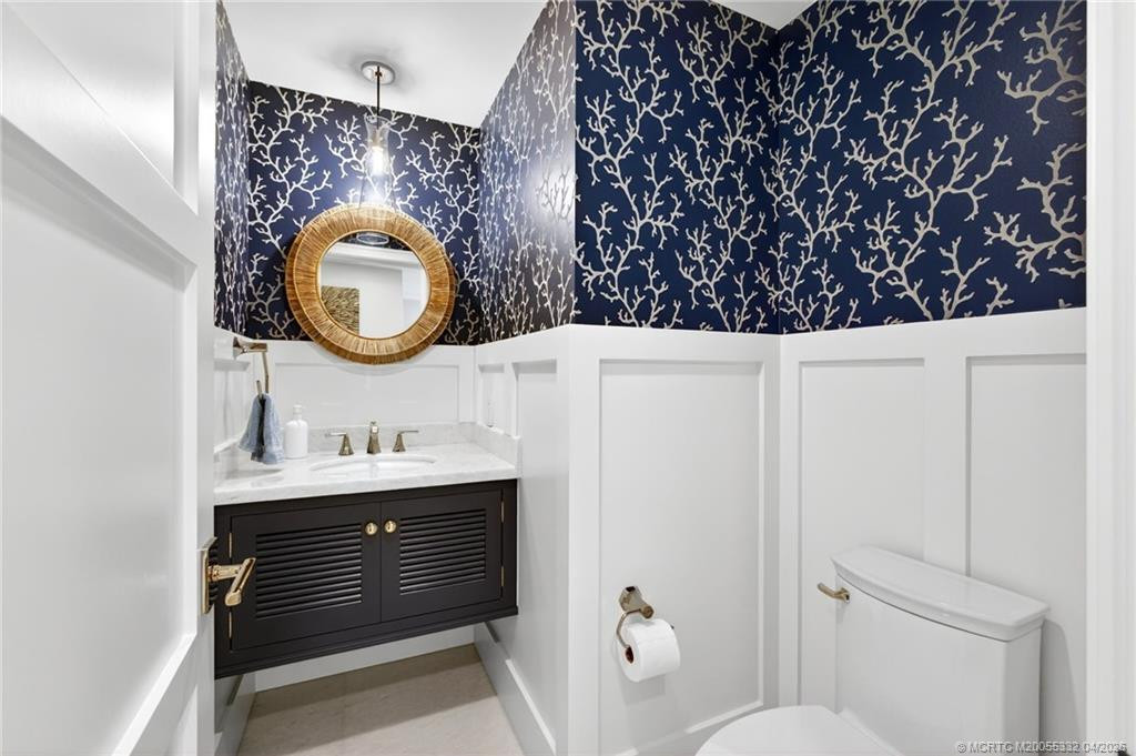 A striking floating vanity and custom millwork gives this powder room pizzazz