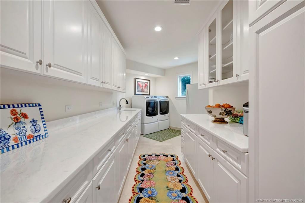 Spacious laundry room with plenty of storage, sink and extra refrigerator