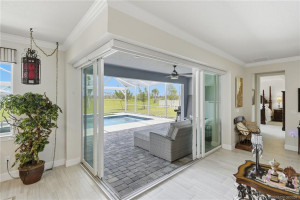 Expansive corner sliding glass doors create a seamless transition between indoor and outdoor living spaces, opening to a covered lanai, screened pool, and peaceful preserve views. This exceptional design fills the home with natural light and provides the perfect setting for entertaining or relaxing in true Florida style.