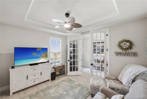 Versatile flex room with elegant glass French doors offers the perfect space for a home office, den, media room, or additional guest accommodations. Features include tray ceiling detail, crown molding, abundant natural light, and stylish finishes that complement the home’s open and modern design.
