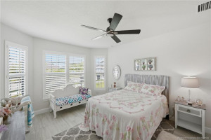 Spacious primary suite offers a peaceful retreat with elegant tile flooring, plantation shutters, abundant natural light, and a bright, airy design. Generous layout provides plenty of room for relaxing while complementing the home’s modern coastal style and luxurious feel.