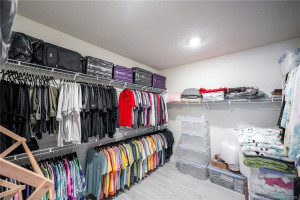 Spacious walk-in primary closet offers abundant storage with extensive shelving and hanging space, providing excellent organization for clothing, shoes, and accessories. Thoughtfully designed for convenience and functionality, this oversized closet complements the home’s luxurious primary suite.