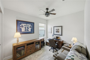 Versatile third bedroom is currently configured as a home office and media room, offering flexible space for work, hobbies, or overnight guests. Features include elegant tile flooring, abundant natural light, and a comfortable layout that easily adapts to your lifestyle needs.