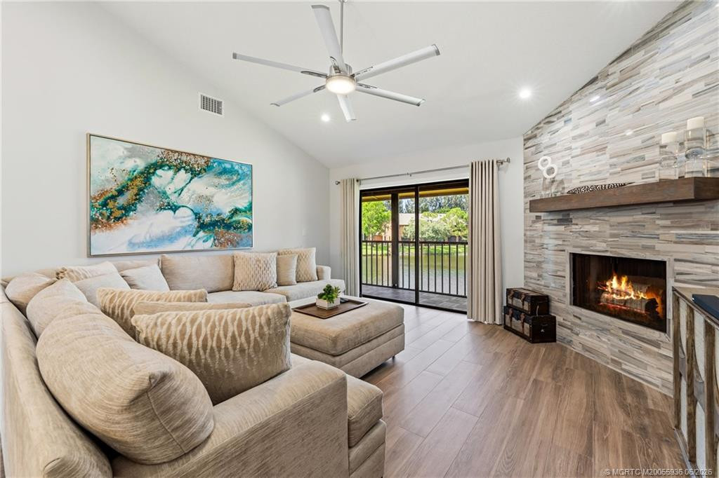 Living area with wood burning fire place and sliders to screened balcony.