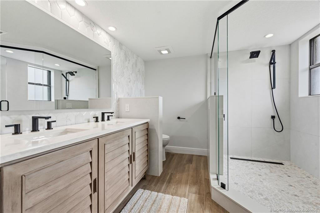 Primary bath with frameless shower, dual vanity and storage.