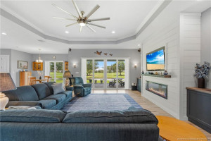 Great room featuring electric fireplace and sliders to paver patio.