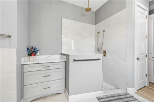 Walk in shower with rain and wall spray fixtures.