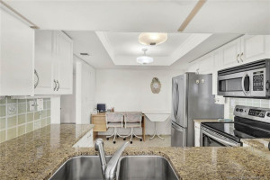 View through the kitchen pass-thru; plenty of room, shaker cabinets, granite counters and tiled backsplash!