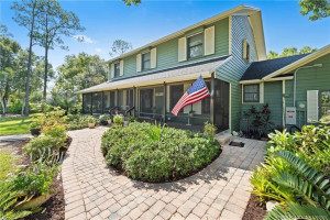 Front of home with screened wrap around porch.